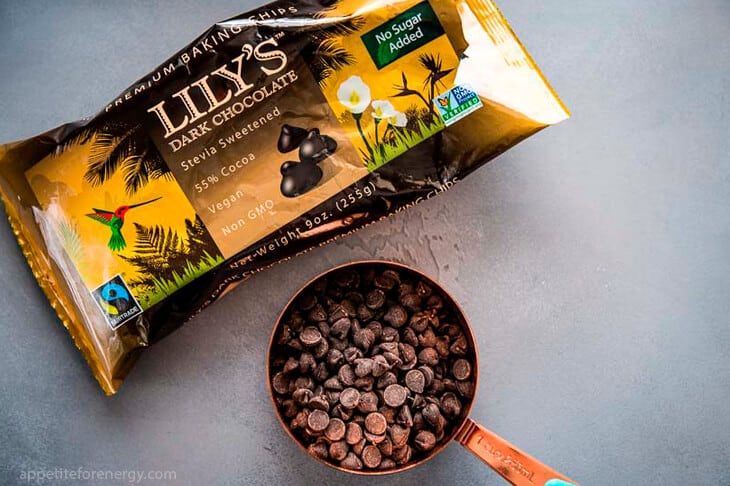 A packet of Lilys Dark Chocolate Chips and a cup measure full of the chocolate chips