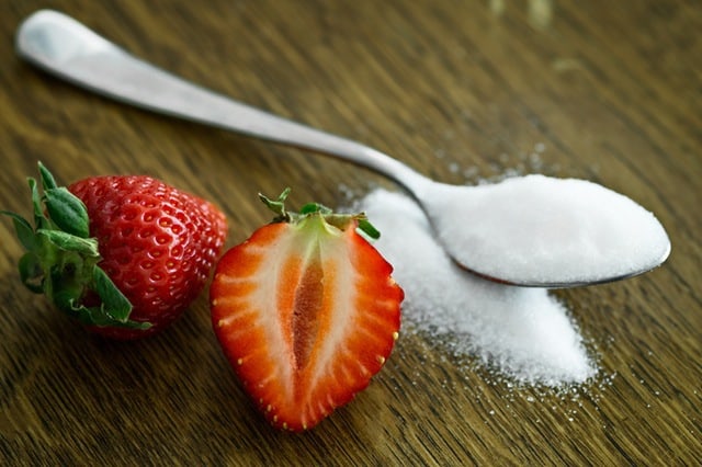 erythritol on a spoon and strawberries