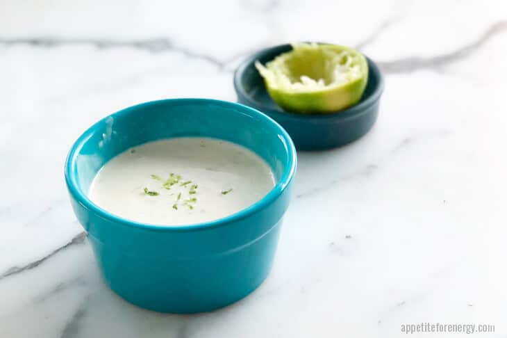 Garlic Lime Aioli in a blue bowl with lime zest on top and squeezed lime