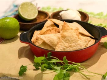 Low-Carb Tortilla Chips in a red bowl with lime, sour cream and cilantro