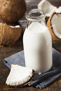 Fresh Organic Coconut Milk in a bottle with fresh coconut pieces