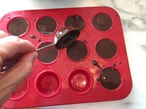 Pouring chocolate fat bomb mixture into molds