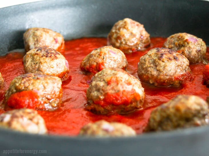Close up of Beef Meatballs Cooking in marinara sauce in skillet