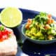 Pan Fried Salmon With Avocado Jalapeno Salsa in a bowl and half a lime