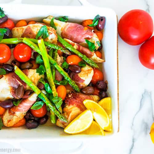 30 Minute Low-Carb Summer Chicken Tray Bake in a baking dish with tomatoes and lemons nearby