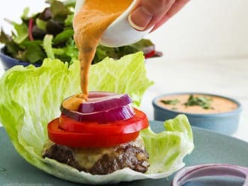 Pouring Chipotle Mayo from bowl onto a Low-Carb Burger
