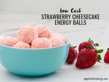 Low-Carb Strawberry Cheesecake Energy Balls in a bowl with some strawberries