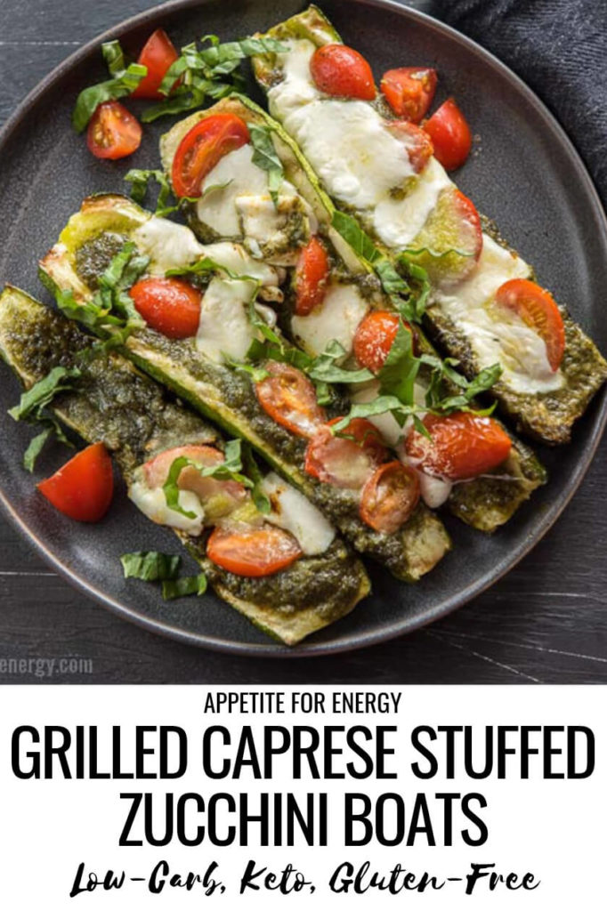 Four Grilled Caprese Zucchini Boats topped with tomatoes, pesto, mozzarella and basil