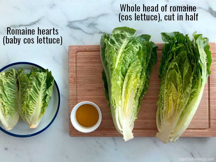 Romaine hearts on a white plate with blue rim and whole romaine lettuce cut in half on a wooden board with a bowl of olive oil