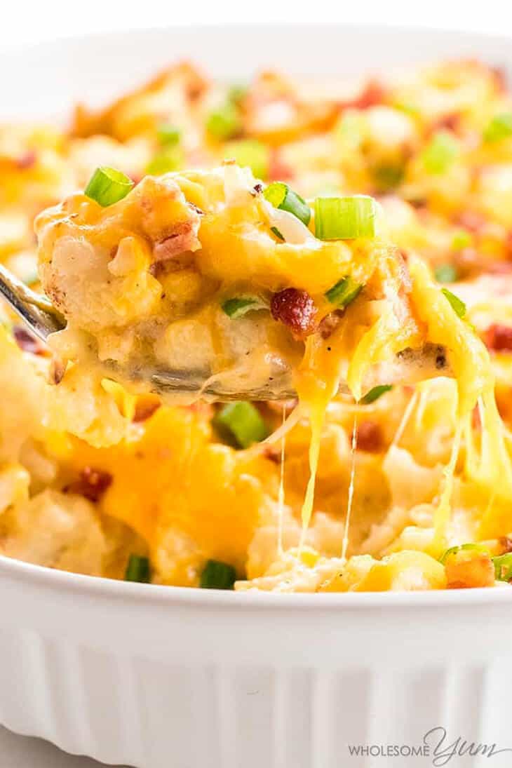 A fork laden with Loaded cauliflower casserole from the dish