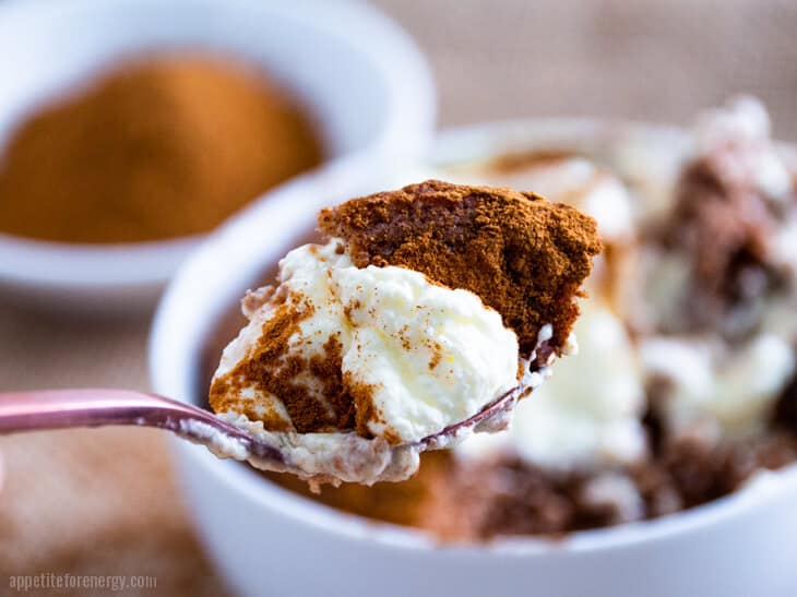 A spoonful of Pumpkin Spice Keto Mug Cake with whipped cream