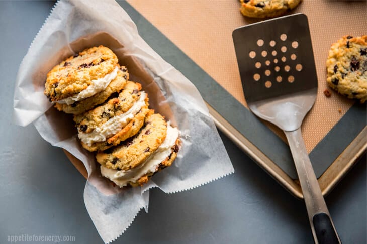 Keto Chocolate Chip Cookie Sandwiches arranged in a tray with parchment paper and a spatula