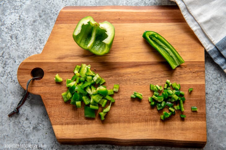 green pepper diced on a wooden chopping board