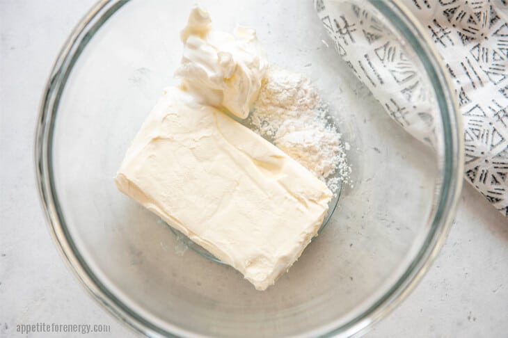 Block of Cream cheese at room temperature in a glass bowl