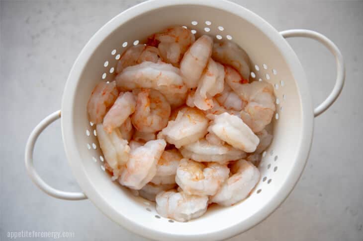 Peeled and deveined shrimp in a white colander
