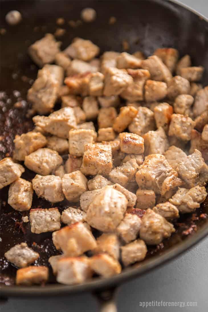 pork pieces cooking in a hot skillet