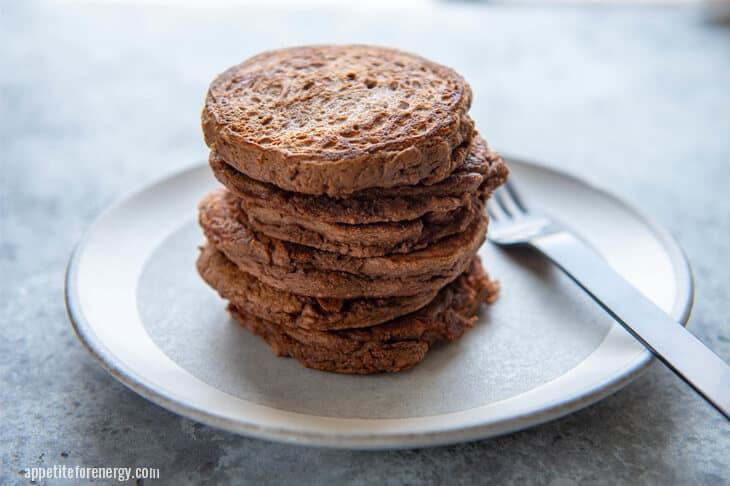 A Stack of Keto Chocolate Protein Pancakes on a white plate with silver fork