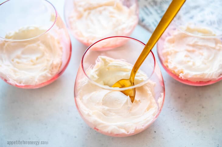 4 Keto Vanilla Cheesecake Puddings in glasses with a gold spoon