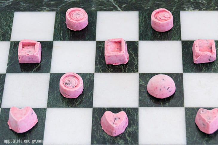 Keto ice cream bites on the white squares of a chess board