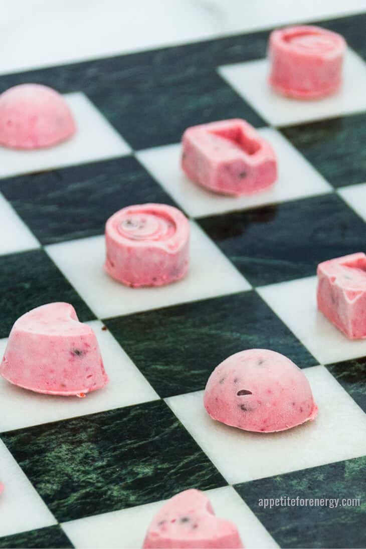 Keto ice cream bites on the white squares of a chess board