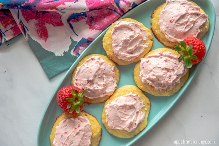 Keto Lemon Sugar Cookie with Strawberry Frosting on a green plate with floral cloth
