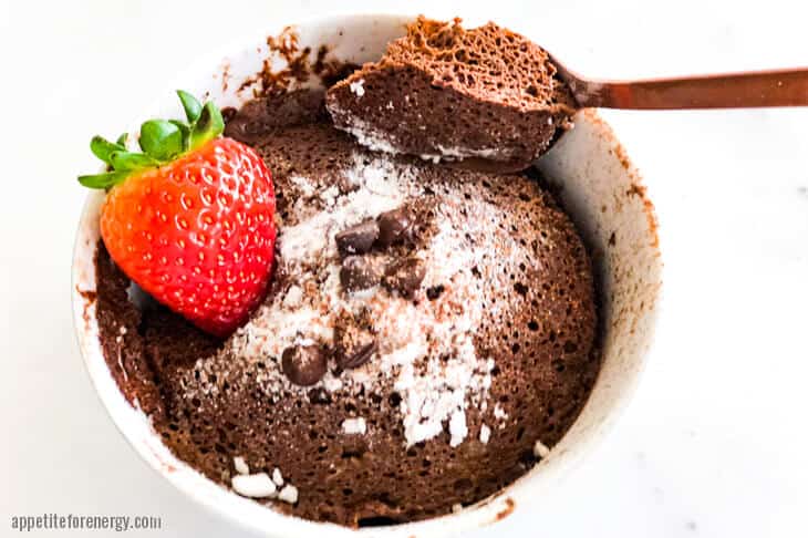 Overhead view of Keto Chocolate Mug cake with strawberry and spoonful