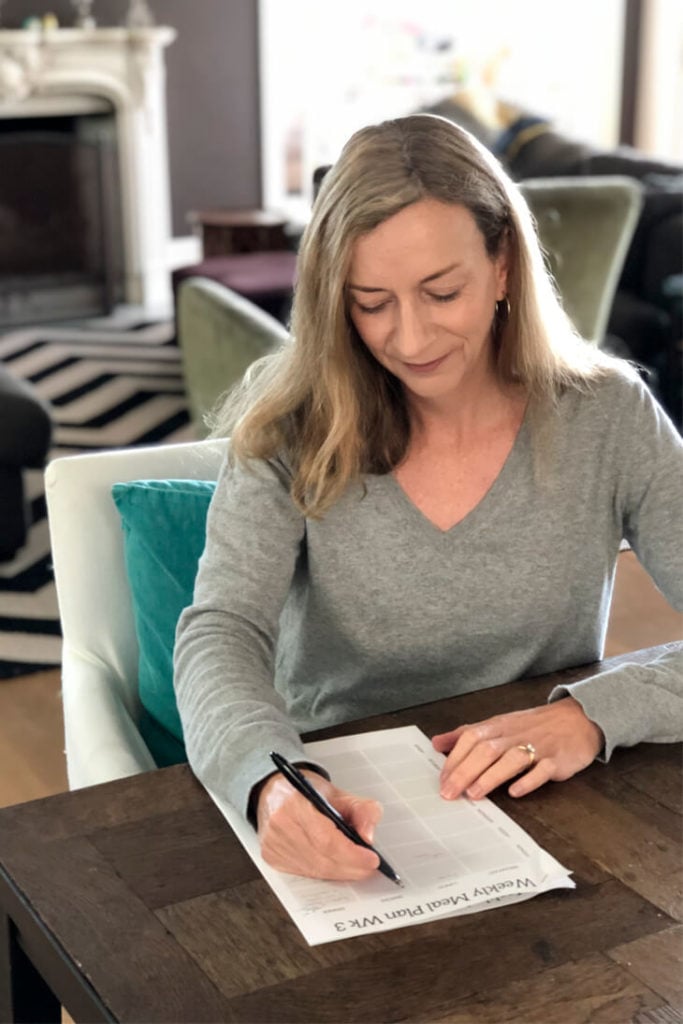 Anna sitting at table writing meal plan